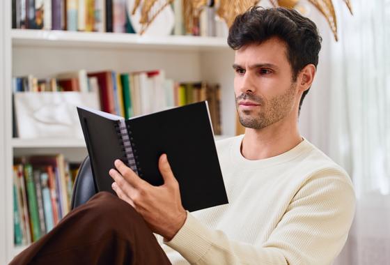 Un cliente leyendo una agenda NorthPlanner junto a una estantería